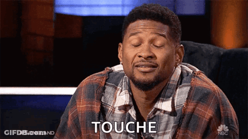 Man In Plaid Shirt Sitting With Eyes Closed Saying Touche GIF