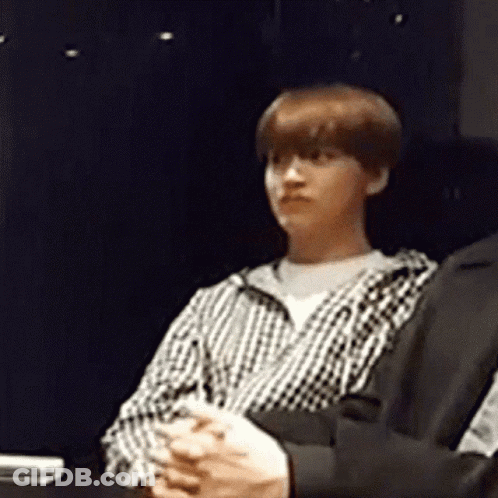 Man In Plaid Shirt Sitting With Folded Hands GIF