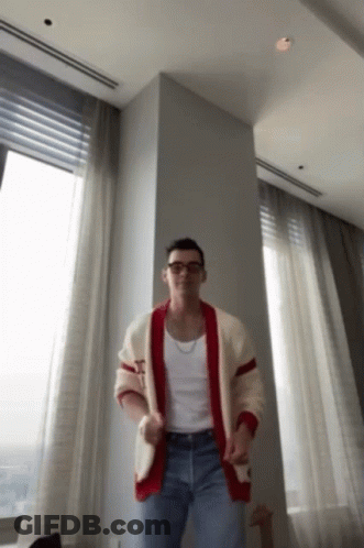 Man In Plaid Shirt Sitting With Hands Up GIF