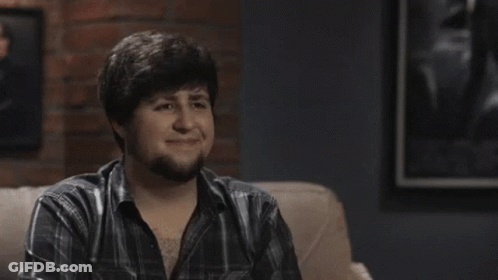 Man In Plaid Shirt Smiling In Front Of Poster GIF