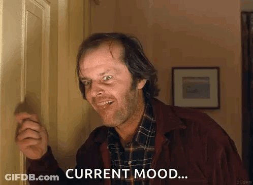 Man In Plaid Shirt Standing In Front Of Door Smiling GIF