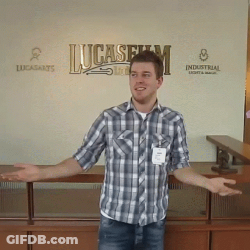 Man In Plaid Shirt Standing In Front Of Lucasfilm Sign GIF