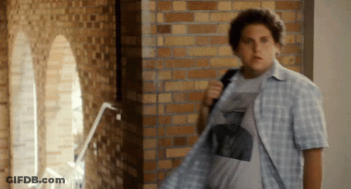 Man In Plaid Shirt Standing In Hallway GIF