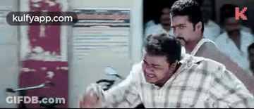 Man In Plaid Shirt Standing Next To Another In Crowd GIF