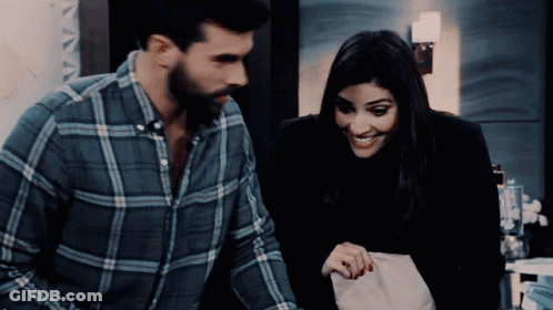 Man In Plaid Shirt Standing Next To Woman In Black Jacket GIF