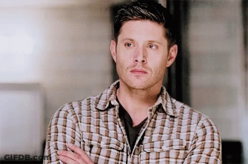 Man In Plaid Shirt Standing With Arms Crossed Looking Away GIF