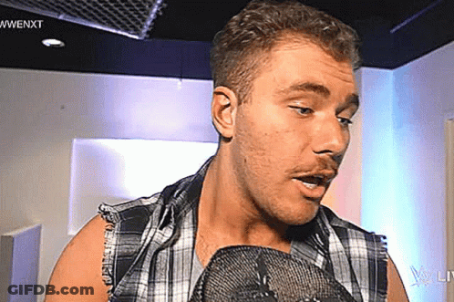Man In Plaid Shirt Talking Into Microphone GIF