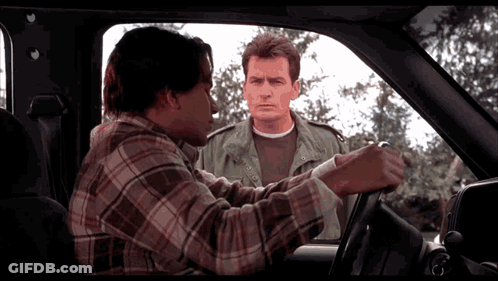 Man In Plaid Shirt Talking To Man In Green Jacket GIF