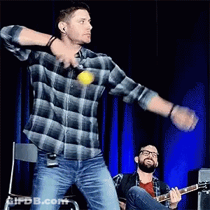 Man In Plaid Shirt Throwing Ball While Another Plays Guitar GIF