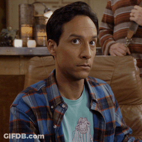 Man In Plaid Shirt With Sheep T-Shirt Looking At Camera GIF