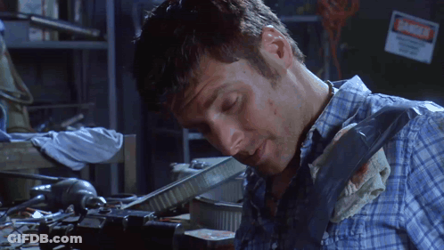 Man In Plaid Shirt Working In Dark Room With Danger Sign GIF