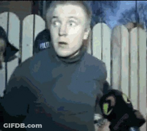 Man In Police Hat In Front Of Fence GIF
