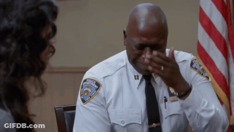 Man In Police Uniform Covering Face GIF