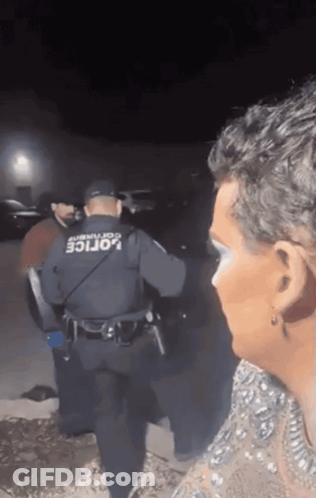 Man In Police Uniform Talking To Woman In Dress GIF