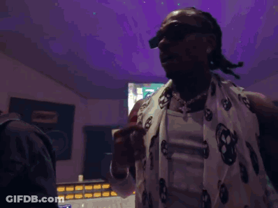 Man In Poncho And Sunglasses On Red Carpet GIF