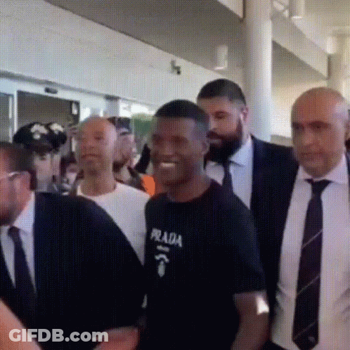 Man In Prada Shirt Surrounded By Suits And Ties GIF