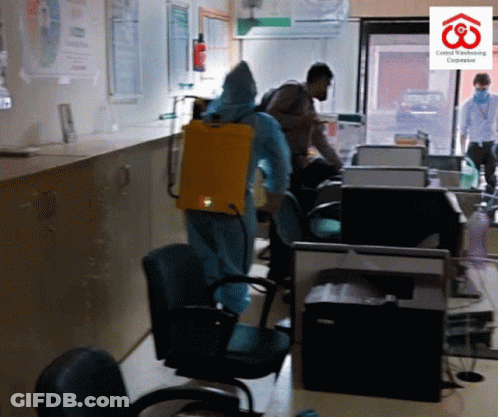 Man In Protective Suit Spraying Room GIF