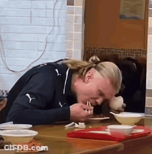 Man In Puma Shirt Eating At Table GIF