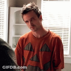 Man In Pumpkin Shirt Looks At Another Man GIF