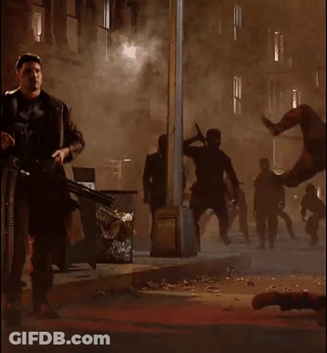 Man In Punisher Costume Holding Machine Gun GIF