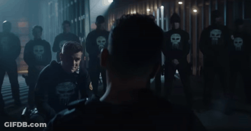 Man In Punisher Sweatshirt In Front Of Clowns GIF