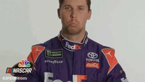 Man In Purple And Orange Racing Suit Making Face GIF