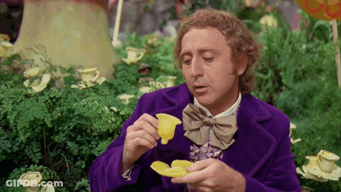 Man In Purple Coat And Bow Tie Holding Yellow Flower GIF
