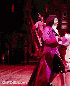 Man In Purple Coat Dancing On Stage GIF