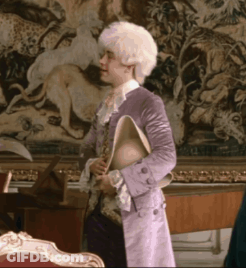 Man In Purple Coat Holding Hat GIF