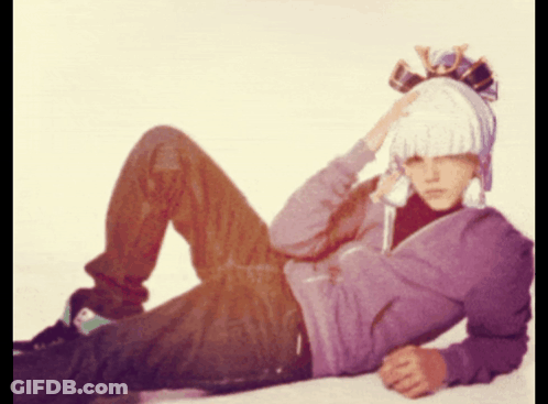 Man In Purple Hoodie And White Hat Lying GIF