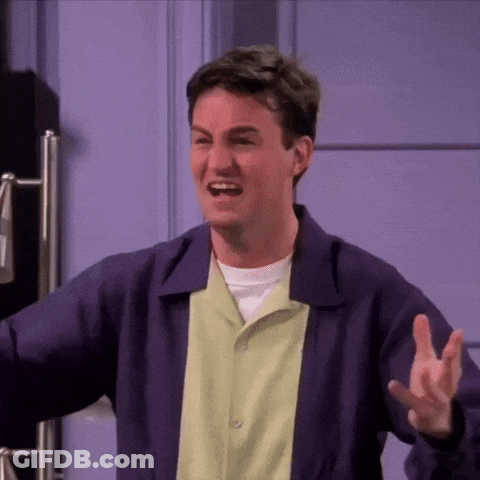 Man In Purple Jacket And Green Shirt Making Funny Face At Door GIF