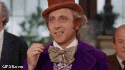 Man In Purple Jacket And Top Hat Eating Chocolate Bar GIF