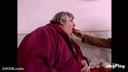 Man In Purple Jacket Eating From Hand GIF