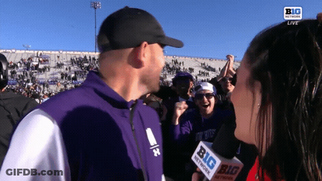 Man In Purple Jacket Interviewed By Woman With Microphone GIF