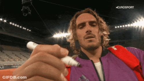 Man In Purple Jacket Writing With Marker In Front Of Eurosport Logo GIF