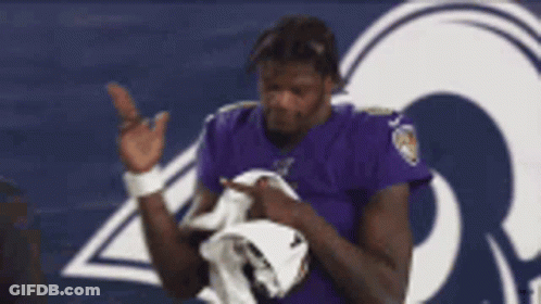 Man In Purple Ravens Shirt Holding White Towel GIF