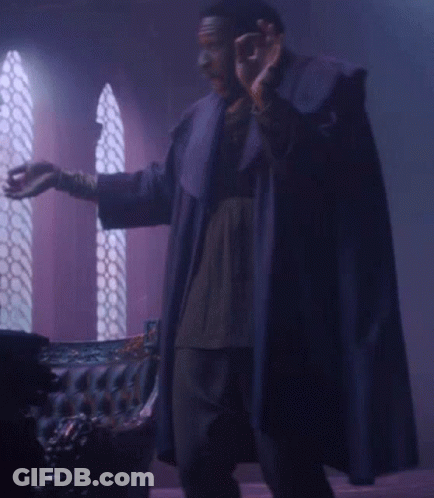 Man In Purple Robe In Front Of Couch GIF