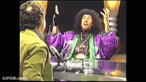 Man In Purple Robe Talking At Table With Microphone GIF