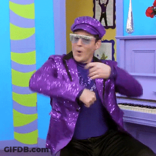 Man In Purple Sequined Suit Dancing By Piano GIF