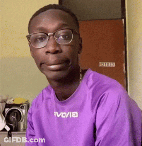 Man In Purple Shirt And Glasses Looking At Camera GIF