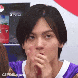 Man In Purple Shirt Covering Mouth With Xingx Sign GIF