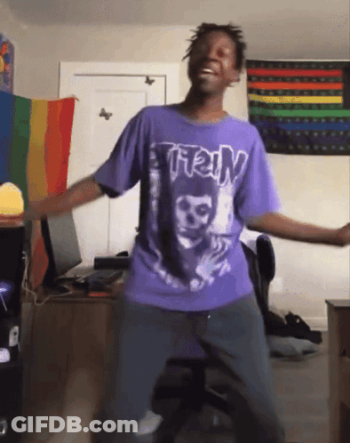 Man In Purple Shirt Dancing In Front Of Rainbow Flag GIF