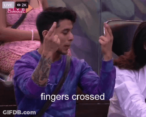 Man In Purple Shirt Giving Middle Finger Saying Fingers Crossed GIF