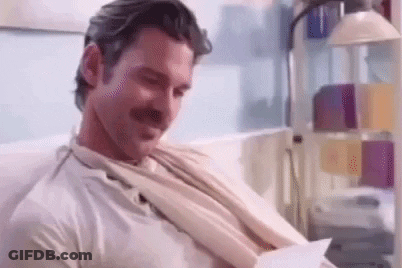 Man In Purple Shirt Holding Purse In Doorway GIF