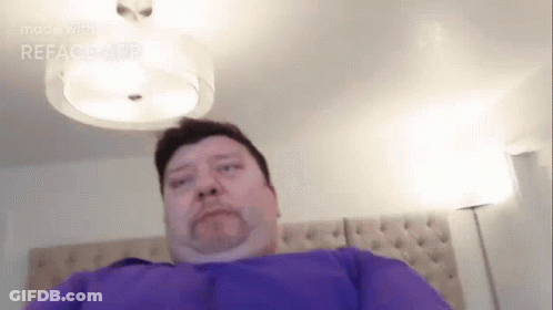 Man In Purple Shirt Laying On Bed GIF