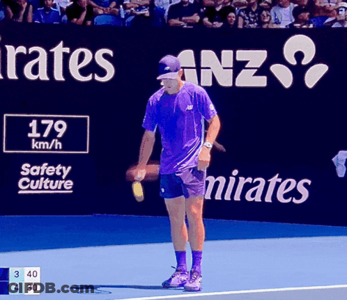 Man In Purple Shirt On Tennis Court In Front Of Emirates Sign GIF