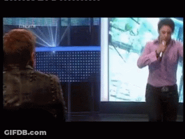 Man In Purple Shirt Singing Into Microphone GIF