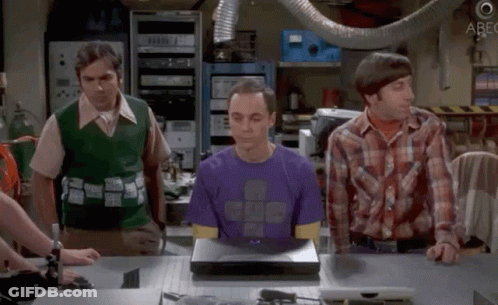 Man In Purple Shirt Sitting At Laptop With Two Men Looking On GIF