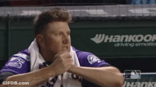 Man In Purple Shirt Sitting In Dugout With Hankook Ad GIF