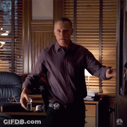 Man In Purple Shirt Standing In Front Of Window GIF